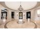 Elegant foyer with a circular marble floor and a grand chandelier at 23414 N 84Th Pl, Scottsdale, AZ 85255