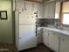 White kitchen cabinets and appliances, including a refrigerator at 2460 E Main St # N12, Mesa, AZ 85213