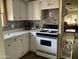 Galley kitchen with white cabinets and gas range at 2460 E Main St # N12, Mesa, AZ 85213