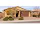 Tan house with brown garage door, landscaping, and brick driveway at 2702 E Saddlebrook Rd, Gilbert, AZ 85298