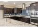 Modern kitchen with dark cabinets, granite countertops, and stainless steel appliances at 2702 E Saddlebrook Rd, Gilbert, AZ 85298