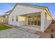 Back patio features gray stone pavers, minimalist landscaping, and multiple sliding glass doors at 27256 N 74Th Ln, Peoria, AZ 85383