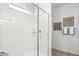 Bright bathroom featuring a glass enclosed shower with tiled flooring and a decorative towel rack at 27256 N 74Th Ln, Peoria, AZ 85383