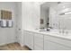 Modern bathroom with dual sinks, white cabinets, and glass-enclosed shower with tiled floor at 27256 N 74Th Ln, Peoria, AZ 85383