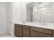 Double vanity bathroom with modern fixtures and a large mirror at 27256 N 74Th Ln, Peoria, AZ 85383