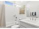 Bright, clean bathroom featuring white fixtures, a shower-tub combo, and decorative accents at 27256 N 74Th Ln, Peoria, AZ 85383