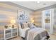 Cozy bedroom with blue and beige striped walls, neutral bedding, and ample natural light at 27256 N 74Th Ln, Peoria, AZ 85383