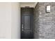 Contemporary front door with stone accents and modern light fixture, creating a welcoming entry at 27256 N 74Th Ln, Peoria, AZ 85383