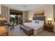 Main bedroom with a king-size bed, access to balcony, and an ensuite bathroom at 2802 E Camino Acequia Dr # 36, Phoenix, AZ 85016