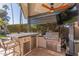 Outdoor kitchen with grill, bar seating and TV at 2824 S Bala Dr, Tempe, AZ 85282