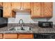 Modern kitchen sink with granite countertop and wood cabinets at 3511 E Baseline Rd # 1147, Phoenix, AZ 85042