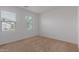 Well-lit bedroom with neutral carpeting and two windows at 40861 W Little Dr, Maricopa, AZ 85138