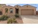 Tan one-story house with a two-car garage and drought-tolerant landscaping at 40861 W Little Dr, Maricopa, AZ 85138