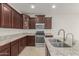 Kitchen features dark wood cabinets, granite countertops, and stainless steel appliances at 40861 W Little Dr, Maricopa, AZ 85138