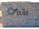 Stone sign with The Duke logo at entrance at 40861 W Little Dr, Maricopa, AZ 85138