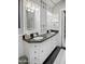 Modern bathroom featuring double vanity, black countertop, and white cabinets at 4142 E Sahuaro Dr, Phoenix, AZ 85028