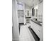 Spa-like bathroom with double sinks, white cabinets, and black tile flooring at 4142 E Sahuaro Dr, Phoenix, AZ 85028