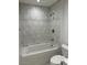 Bathroom with a bathtub and marble tile shower surround at 4200 N Miller Rd # 112, Scottsdale, AZ 85251