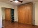 Bedroom with wood floors and a large built-in wooden cabinet at 4200 N Miller Rd # 112, Scottsdale, AZ 85251