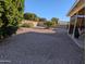 Large backyard with gravel, mature trees, and a covered patio at 5110 E Edgewood Ave, Mesa, AZ 85206