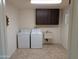 Laundry room with washer, dryer, cabinets and utility sink at 5110 E Edgewood Ave, Mesa, AZ 85206