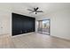 Bright living room featuring a modern accent wall, light wood floors, fan and sliding glass doors leading to a balcony at 5345 E Van Buren St # 226, Phoenix, AZ 85008