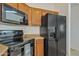 Black appliances and wood cabinets in this corner of the kitchen at 544 N Alma School Rd # 9, Mesa, AZ 85201