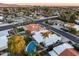 This aerial view showcases a home's backyard pool and the surrounding neighborhood with mature trees and wide streets at 6320 E Kings Ave, Scottsdale, AZ 85254