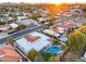 Expansive aerial view of a home with a private pool, set against a backdrop of a neighborhood at sunset at 6320 E Kings Ave, Scottsdale, AZ 85254