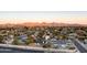 A wide aerial shot of a neighborhood, capturing homes with mountain views during a serene sunset at 6320 E Kings Ave, Scottsdale, AZ 85254