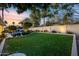 Landscaped backyard featuring a manicured lawn, putting green, and a sparkling blue swimming pool at 6320 E Kings Ave, Scottsdale, AZ 85254