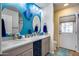 Bathroom with dual sink vanity, vibrant blue wall, and access to outdoor patio area at 6320 E Kings Ave, Scottsdale, AZ 85254