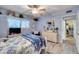 Bright bedroom features light wood floors, ceiling fan, and a classic white dresser at 6320 E Kings Ave, Scottsdale, AZ 85254