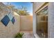 Private courtyard with textured walls, decorative tiles, a window, and greenery at 6320 E Kings Ave, Scottsdale, AZ 85254