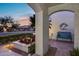 Covered front porch with elegant columns, stylish bench, and views of manicured landscaping at 6320 E Kings Ave, Scottsdale, AZ 85254