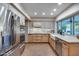 Well-lit kitchen featuring stainless appliances, a farmhouse sink, and backyard view at 6320 E Kings Ave, Scottsdale, AZ 85254