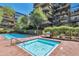 Beautiful pool and spa area with pristine water, brick patio, and grill, surrounded by lush landscaping and upscale apartments at 7161 E Rancho Vista Dr # 3002, Scottsdale, AZ 85251