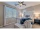 Bedroom with a white wooden bed frame, blue blanket and window blinds at 10110 W Redbird Rd, Peoria, AZ 85383