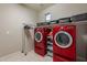 Laundry room with red washer and dryer, shelving, and hanging rack at 10110 W Redbird Rd, Peoria, AZ 85383