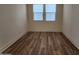 Well-lit bedroom featuring wood-look floors and two windows at 10150 E Thistle Ave, Mesa, AZ 85212