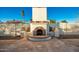 Outdoor fireplace with flagstone patio and surrounding landscaping at 102 W El Caminito Dr, Phoenix, AZ 85021