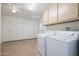 Laundry room with washer, dryer, and ample cabinet storage at 10629 W Willow Creek Cir, Sun City, AZ 85373