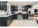 Modern kitchen with dark cabinets, stainless steel appliances, and granite countertops at 10902 W Flanagan St, Avondale, AZ 85323