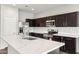 Spacious kitchen featuring dark cabinetry, quartz countertops, and stainless steel appliances at 11225 E Marigold Ln, Florence, AZ 85132