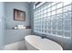 Relaxing bathroom with a freestanding tub and a window featuring glass blocks at 11748 N 80Th Pl, Scottsdale, AZ 85260