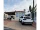 Tan mobile home with carport, patio furniture, and a white SUV parked in the driveway at 1494 W Pawnee Ave, Apache Junction, AZ 85119