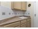 Laundry room with cabinets, a utility sink, and built-in shelving at 15665 W Azalea Ln, Surprise, AZ 85374