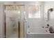 Bathroom with shower, bathtub, and window at 17680 W Lilac St, Goodyear, AZ 85338