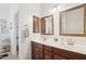 Double vanity bathroom with dark wood cabinets and large mirrors at 17680 W Lilac St, Goodyear, AZ 85338