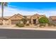 Tan house with a two-car garage and nicely landscaped yard at 18137 N Estrella Vista Dr, Surprise, AZ 85374